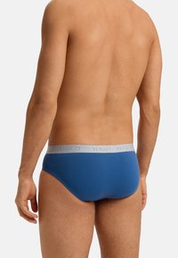 Mannen blauwe katoenen slips met een lichtgrijze tailleband met het "HANRO" logo. Glad textuur, stevige pasvorm en klassiek slipontwerp.