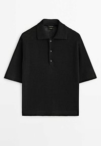 Polo en maille noire à manches courtes avec trois boutons et un col et un bas côtelés, posé à plat sur un fond blanc.