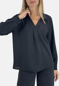 Zwarte blouse met lange mouwen, een V-hals en plooidetail. Gemaakt van een gladde stof, met manchetknopen en een ontspannen pasvorm.
