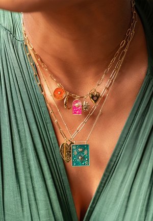 Colliers en or plaqué présentant divers pendentifs : un pendentif circulaire orange, une porte verrouillée rose, un cœur et un charm rectangulaire teal avec des détails.