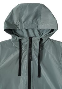 Veste à capuche gris clair avec fermeture éclair frontale et cordons noirs étiquetés « Cecil Outerwear ».
