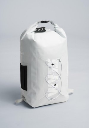 Mochila blanca impermeable con cierre enrollable, bolsillo lateral negro y cordón elástico entrecruzado en la parte delantera, sobre un fondo sencillo.