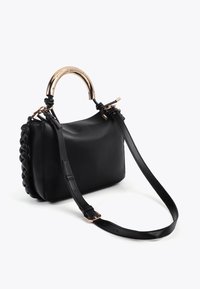 Borsa in pelle nera con lato intrecciato, manico circolare in tono oro, tracolla in pelle nera regolabile, texture liscia e forma strutturata.