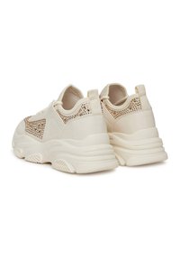 Beżowe sneakersy z siateczkowymi i teksturowanymi akcentami, wyściełanym kołnierzem, grubą podeszwą oraz dekoracyjnymi detalami wzdłuż pięty i boków.