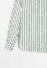 Chemise à manches longues boutonnée avec des rayures verticales grises et blanches et des manches à poignets sur fond blanc.