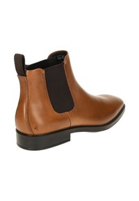 Stivale alla caviglia in pelle marrone con pannello elastico laterale, punta arrotondata e suola piatta in gomma nera. Include un sottile dettaglio di branding vicino al tallone.