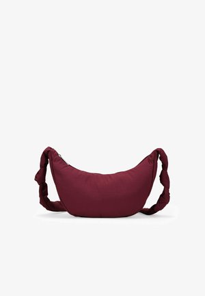 Maroon fabric hobo bag with a curved shape, braided strap, and a zipper closure along one side. Smooth texture with minimal branding.