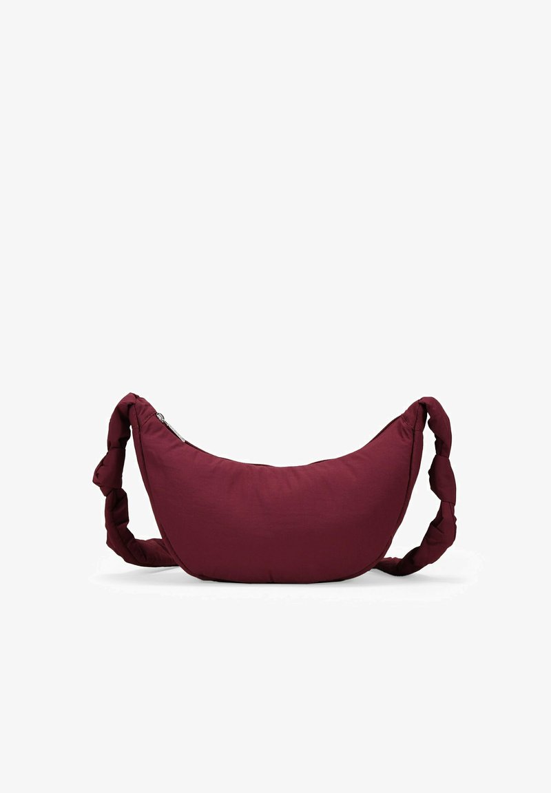 Borsa hobo in tessuto bordeaux con una forma curva, tracolla intrecciata e chiusura con zip su un lato. Texture liscia con branding minimale.
