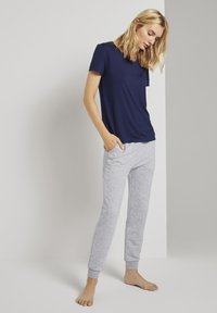 Marineblå T-shirt med kort ärm och rund halsringning som passar med ljusgrå sweatpants med ribbade muddar och fickor. Mjuk tygtextur.