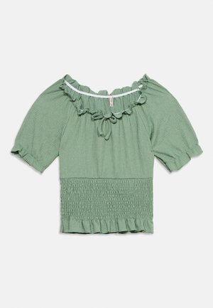 Blusa verde chiaro con maniche corte a sbuffo, scollo a spalle scoperte con volant, dettaglio con laccio, vita arricciata e orlo a volant.