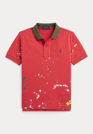 Polo de algodón rojo con cuello verde oliva. Presenta patrones de salpicaduras de pintura en blanco, verde y amarillo. Con tapeta de dos botones.