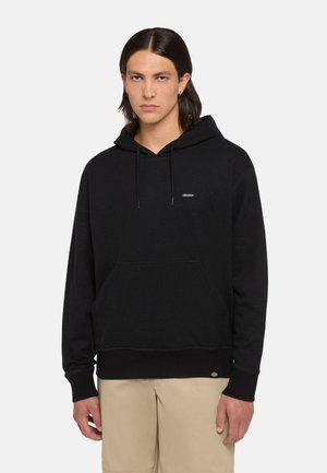 Black hooded sweatshirt with a kangaroo pocket, ribbed cuffs, and hem. Features a small logo label on the chest and soft, textured fabric.