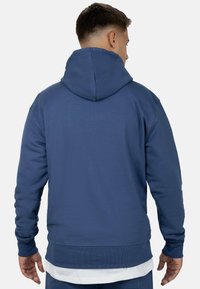 Felpa con cappuccio blu dal finish testurizzato. Presenta polsini e orlo a costine, con una vestibilità rilassata e un design semplice. Senza marchi visibili.