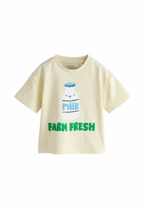 Pamucna majica krem boje s kratkim rukavima, s grafikom boce mlijeka i natpisom "FARM FRESH" u zelenoj boji.