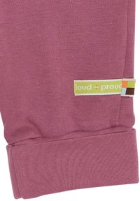 Rosa Baumwoll-Sweatpants mit gerippten Bündchen und einem Stoffetikett mit dem "loud + proud" Logo in grün und bunten Quadraten. Weicher Stoff, lässiges Design.