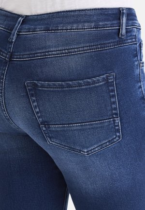 Dark blue denim jeans featuring a fitted design with a single back pocket. The fabric displays a subtle texture with a slight faded effect.