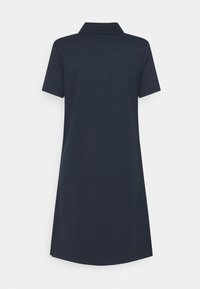 Mörkblå polo klänning med korta ärmar och krage, tillverkad av en texturerad tyg. Har en rak skärning och något rundad nederkant.