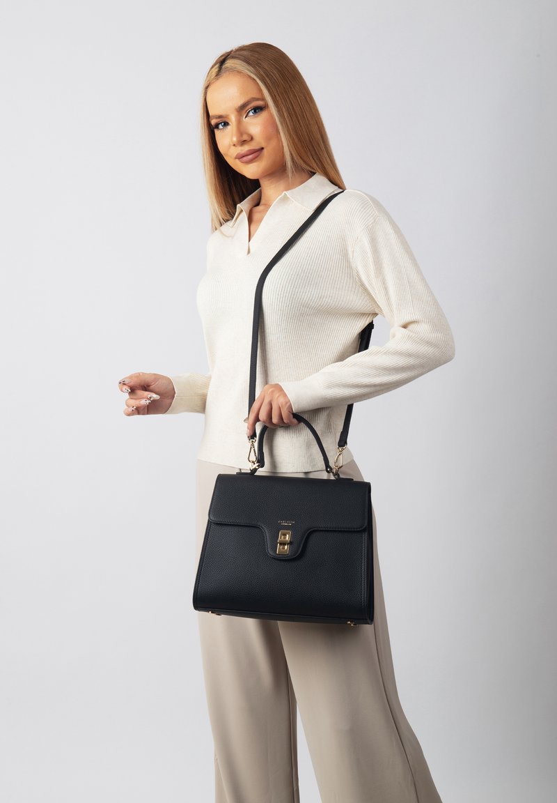 Black leather handbag with a structured design, gold hardware, and a top handle. Features an adjustable shoulder strap and a textured finish.