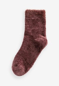 Luddiga strumpor i en djup burgundy-färg. Har en tjock, mjuk textur och en något fluffig krage högst upp. Rundad tådesign.