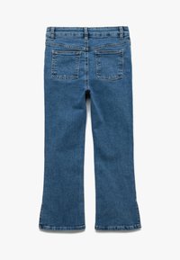 Siniset farkut, joissa on levenevät lahkeet, kaksi takataskua, perinteinen vyötärö ja pehmeä rakenne.