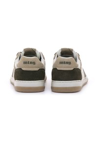 Zapatillas verdes y beige con material de ante y cuero. Media suela blanca y suela de goma. Presentan un logotipo en el talón y detalles de costura sutiles.