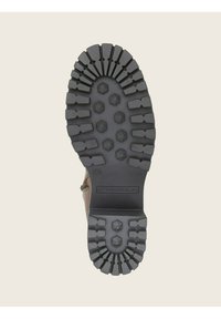 Suela de bota de goma negra con un diseño de banda de rodadura robusto, que presenta patrones hexagonales y un logo de la marca. Tamaño marcado como 40.