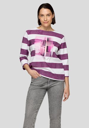 Langärmliges Hemd mit lila und weißen Streifen, mit einem pinken Grafikelement auf der Vorderseite. Der Stoff hat ein strukturiertes Aussehen.