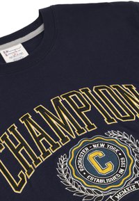 Sudadera de color azul marino con bordado amarillo llamativo de la palabra "CHAMPION" y un emblema circular con "ROCHESTER NUEVA YORK".
