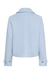 Veste courte bleu clair en tissu texturé. Présente un col à revers et des poignets avec des accents de boutons dorés.