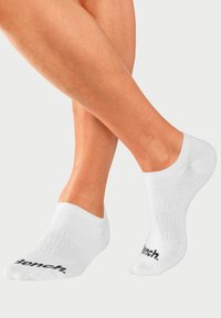 White ankle socks made of cotton blend, featuring a ribbed texture and black "Bench." logo on the side. No-show design.