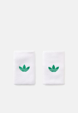 Hvite bomullsvelour håndleddsbånd med grønn brodert trefoil-logo. Myk tekstur, litt elastisk, rektangulær form.