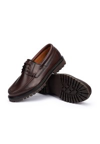 Chaussures en cuir marron avec une forme arrondie, dotées d'un laçage et d'une semelle en caoutchouc épaisse avec un motif texturé pour une meilleure adhérence.