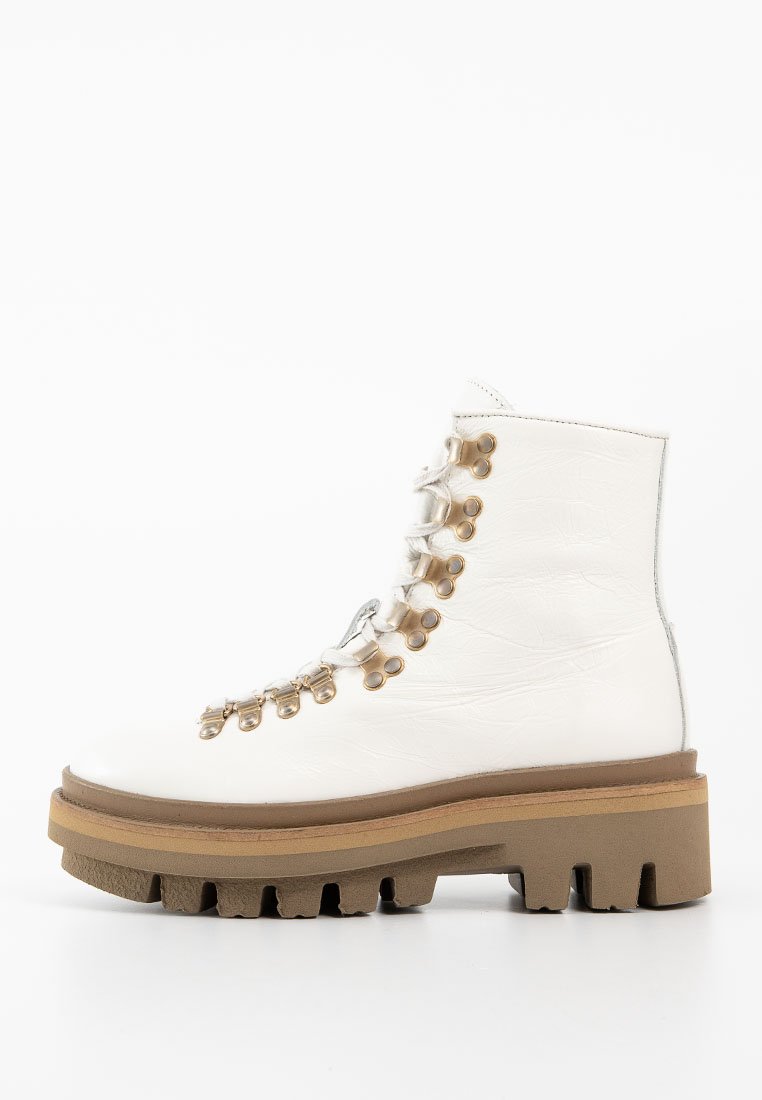Weiße Leder-Ankle-Boots mit dickem braunem Absatz. Merkmale sind metallische Ösen und Schnürsenkel, strukturierte Oberfläche und robustes Design.