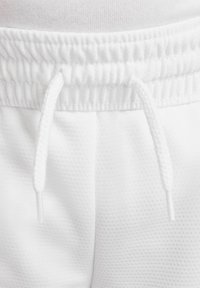 Κοντινή λήψη λευκού υφασμάτινου σορτς με ελαστική μέση και λευκά πλεχτά κορδόνια δεμένα μπροστά.