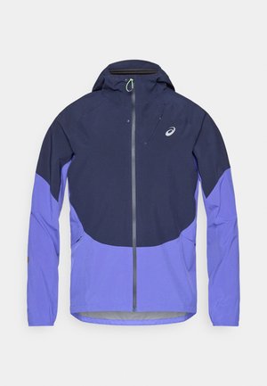 Giacca impermeabile con cappuccio, chiusura con zip e pannelli contrastanti blu navy e viola. Realizzata in tessuto traspirante con tasche frontali.
