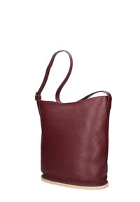 Dieprode leren handtas met een zachte textuur, een smalle schouderriem en een afgeronde onderkant. Heeft een minimalistisch ontwerp zonder zichtbare hardware.