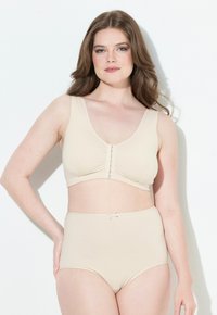 Beiger BH mit V-Ausschnitt und Frontverschluss, mit gerafften Details; kombiniert mit high-waisted beigen Unterhosen mit einer Schleifenakzent.