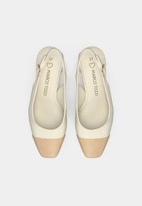 Μπεζ παπούτσια slingback με ματ φινίρισμα, τετράγωνα δάχτυλα και χρυσή λεπτομέρεια. Έχει μέγεθος 37 που είναι ανάγλυφο στο εσωτερικό του. Λείος υφής με ελαφριά γυαλάδα.