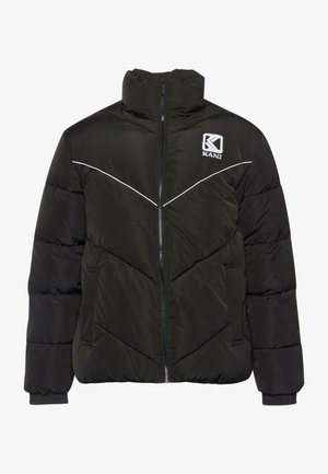 Must hüljes mustas, kõrge kraega, esitaskuga, valge kontrastõmblusega ja logoga vasakul rinnal. Omab qviltimisdisaini ja küljetaskuid.