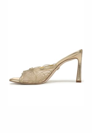 Mule aperte in oro con tacco a spillo alto, caratterizzate da una tomaia trasparente decorata con ricami metallici intricati e bordi smerlati.