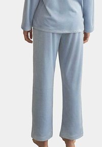 Ensemble de pyjama en polaire bleu clair avec des manches longues et un pantalon à coupe décontractée. Présente une texture douce et un design simple et sans ornement.