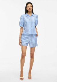 Camicia a maniche corte a righe blu chiaro e pantaloni corti abbinati, entrambi con una texture liscia. La camicia ha un colletto e una vestibilità ampia.
