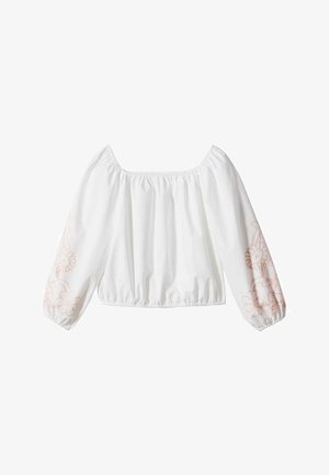 Blouse blanche à épaules dénudées avec manches longues bouffantes et broderie florale rose pâle sur le bas des manches.