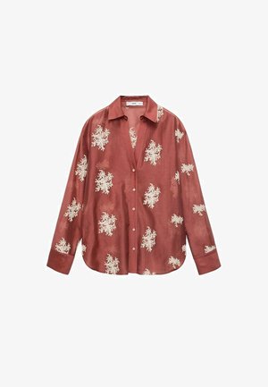 Camicia a maniche lunghe color ruggine con chiusura a bottoni e motivi floreali bianchi, realizzata in un tessuto liscio con una vestibilità comoda.