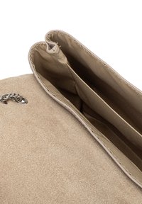 Interno della borsa in suede beige con due scomparti; foderato in tessuto marrone chiaro, presenta un bordo liscio e un dettaglio in catena argentata all'apertura.