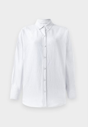 Camisa branca de botões feita de tecido texturizado, com colarinho, mangas longas e uma tira frontal com seis botões visíveis.