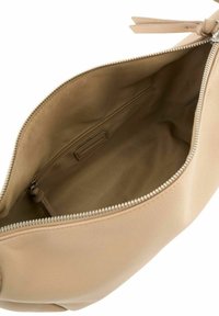 Pochette en cuir beige avec une fermeture éclair, montrant un intérieur en tissu doux et une poche zippée intérieure.