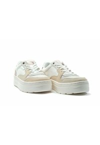 Weiße und beigefarbene Sneaker mit einem strukturierten Obermaterial aus Wildleder und Canvas, ausgestattet mit Schnürsenkeln, einer dicken weißen Sohle und einem dezenten rosa Akzent.