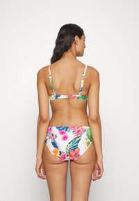 Damernas bikini med ett flerfärgat blommönster på en vit bakgrund; justerbara band, spänne och mjukt tyg.