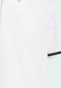 Polo shirt blanc avec un tissu texturé, col standard, trois boutons et des accents noirs sur les manches.